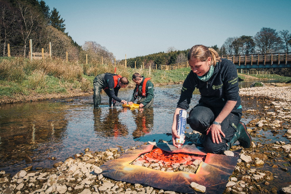 EA team members making marks on river banks to track collected information